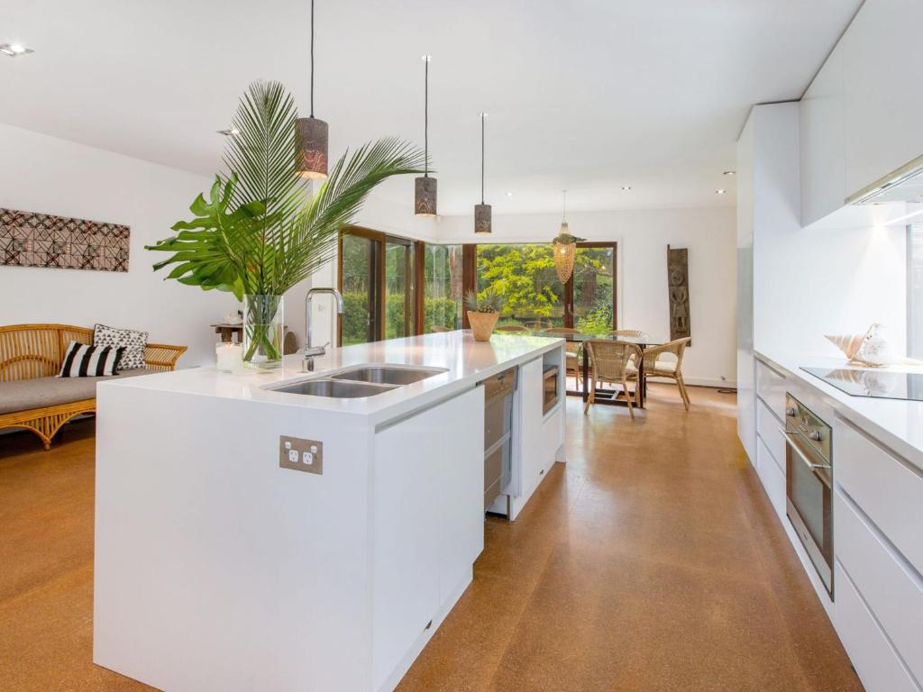 a kitchen with white counters and a living room at LANAI HOUSE BALNARRING BEACH in Balnarring Beach