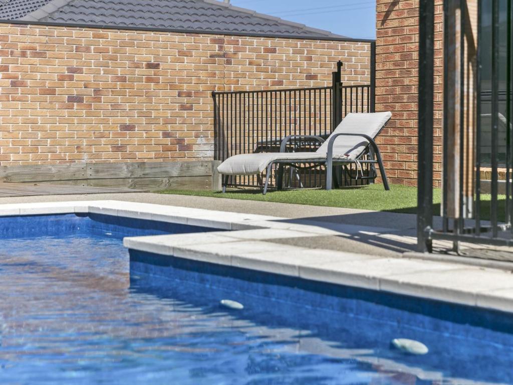 a chair sitting next to a swimming pool at Sweetlands Sanctuary in Mount Martha