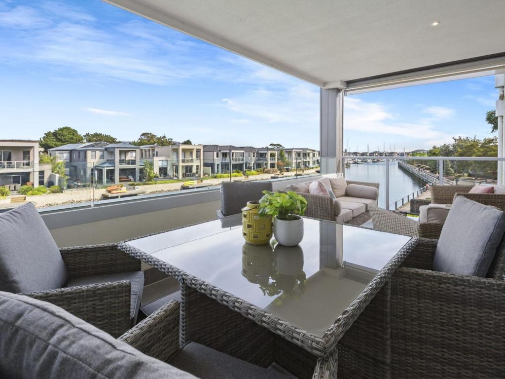 a patio with a table and chairs on a balcony at Marina View in Safety Beach