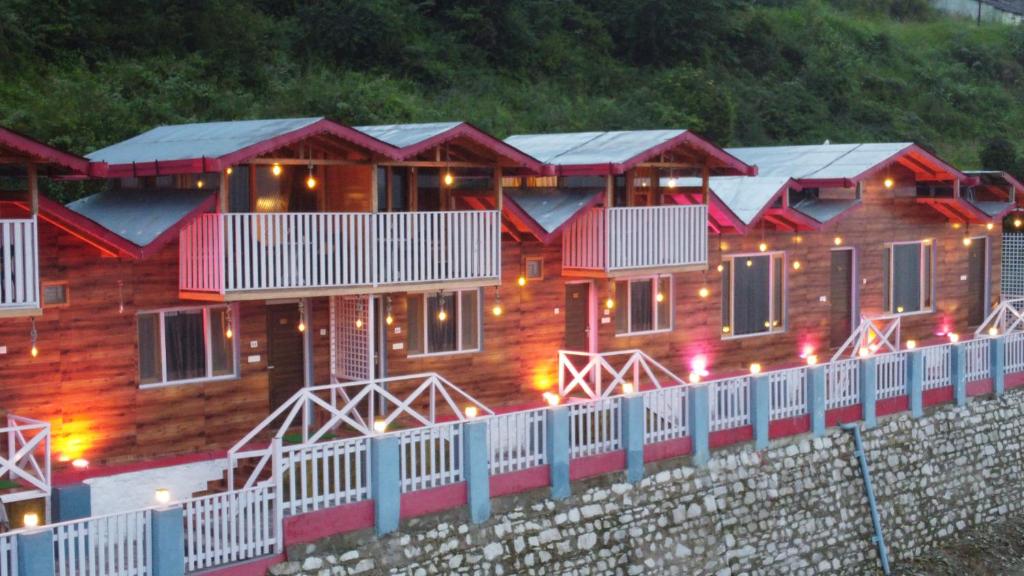 a row of houses with lights on a wall at Rooftop Cottages & Restaurant, Pangot in Nainital