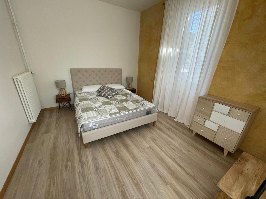 a bedroom with a bed and a dresser and a window at Smart Living Swiss in Chiasso
