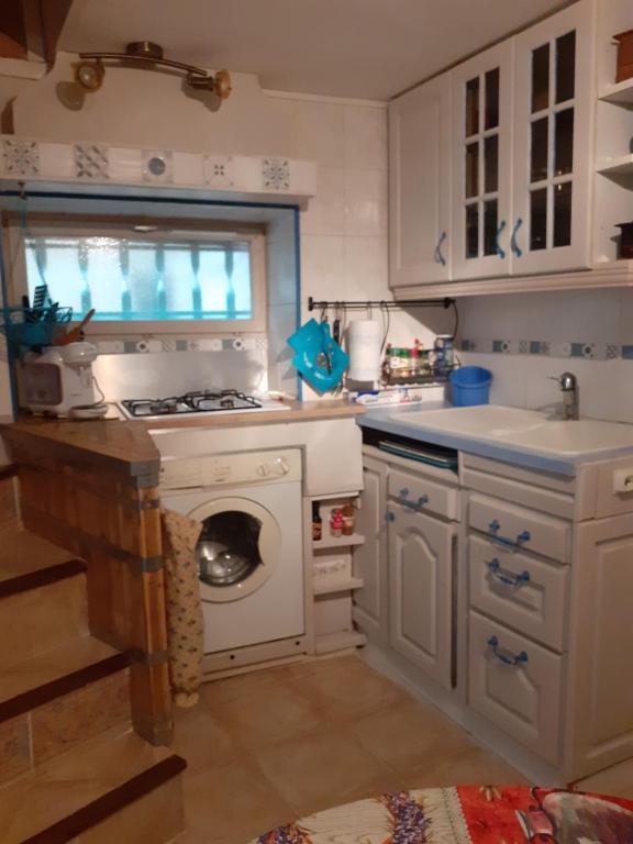 a kitchen with a stove and a washing machine at L'Oustalet in Beaumes-de-Venise