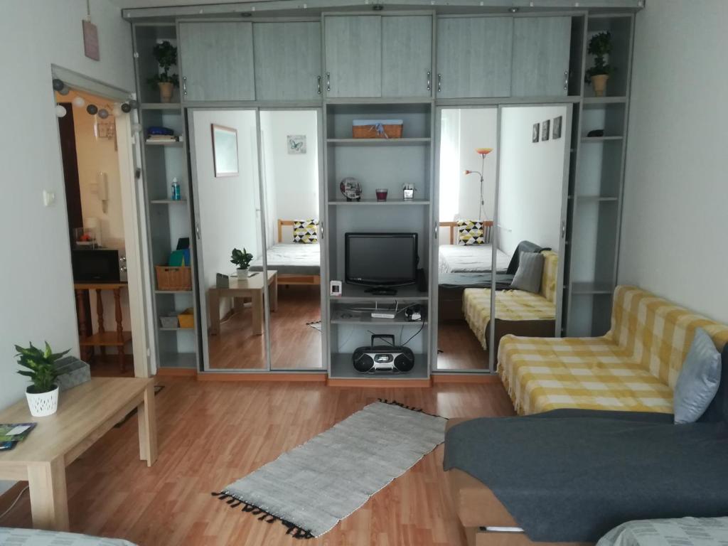 ein Wohnzimmer mit einem Sofa und einem TV in der Unterkunft Var Apartman in Miskolc