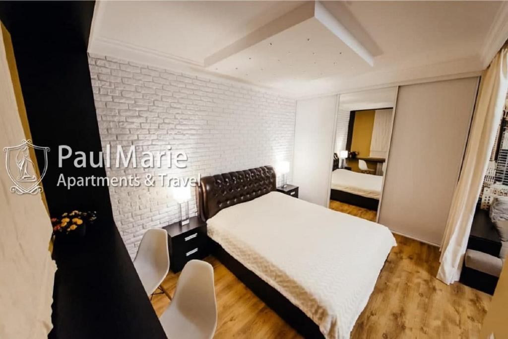 a bedroom with a bed and a white brick wall at PaulMarieApartments on Sovetskaya in Brest