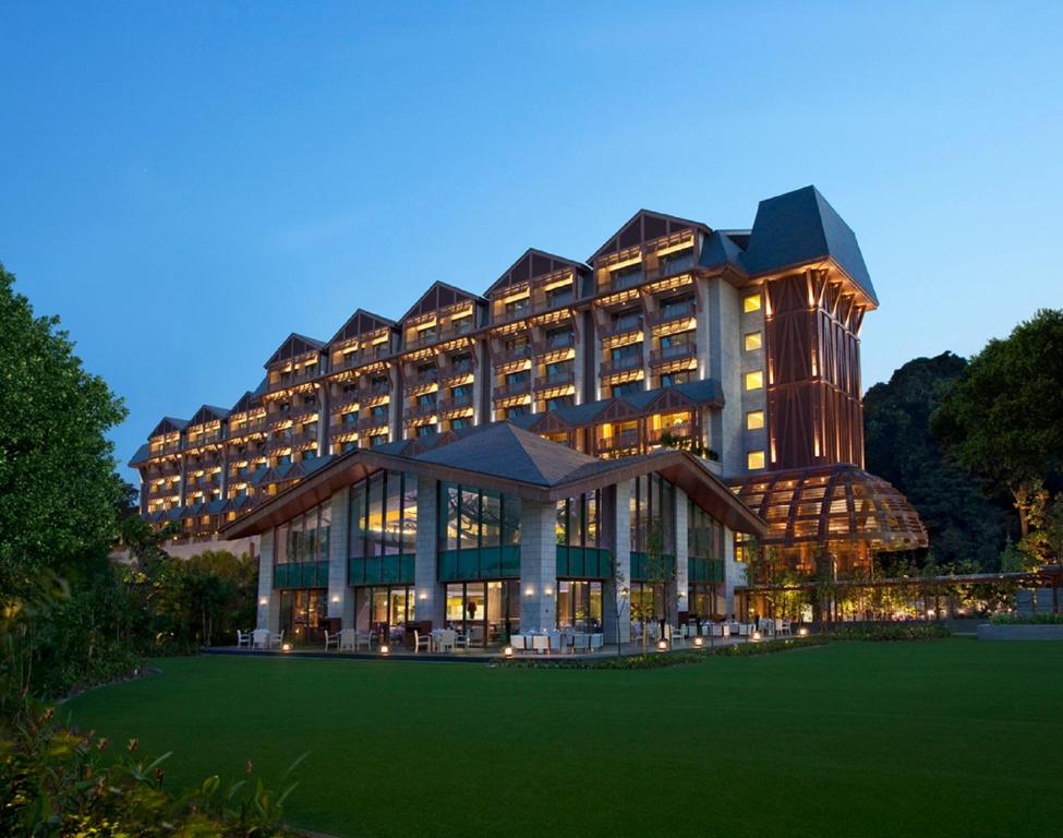 een groot gebouw met een groen gazon ervoor bij Resorts World Sentosa - Equarius Hotel in Singapore