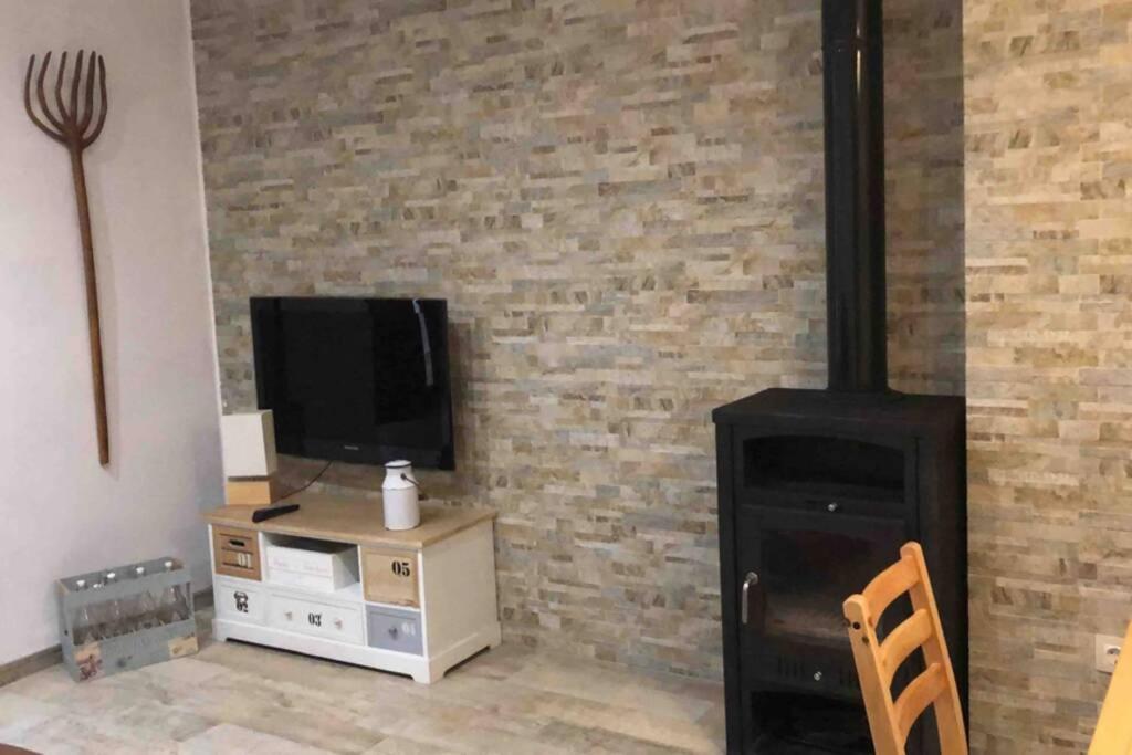a living room with a wood stove and a tv at Casa Fineta in Algar de Palancia