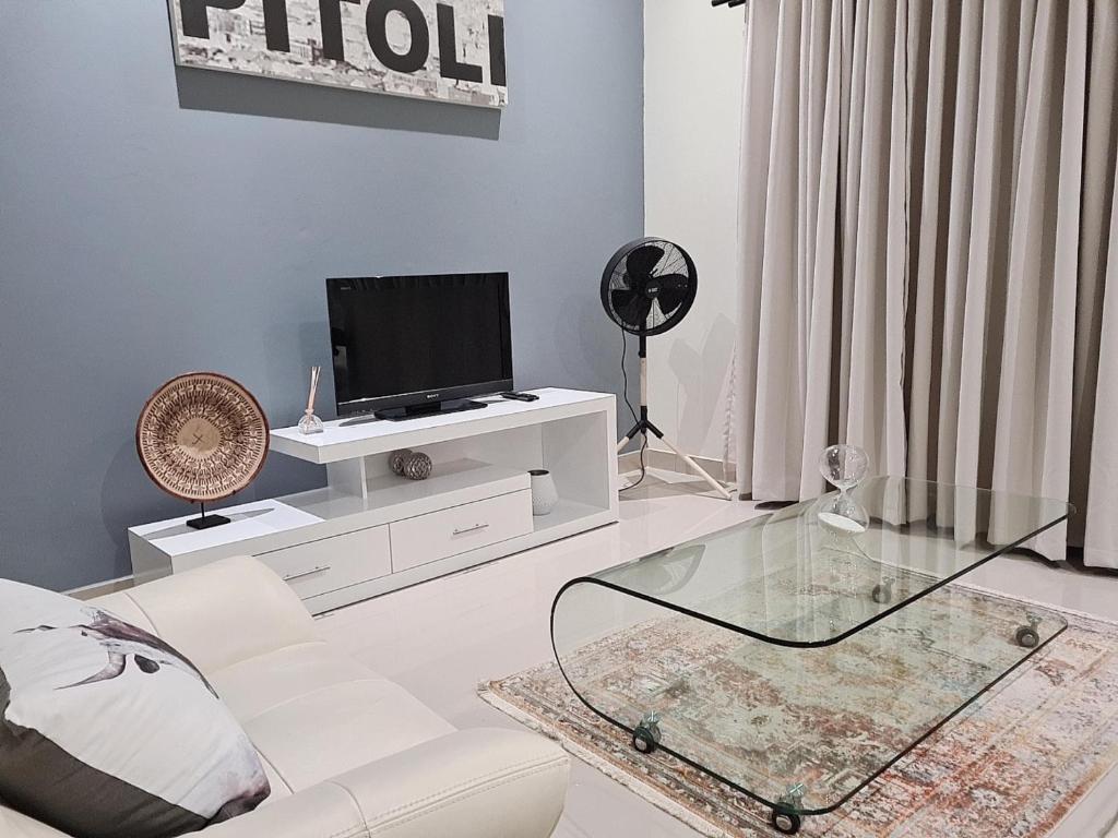 a living room with a white couch and a tv at Modern Executive Unit in East London