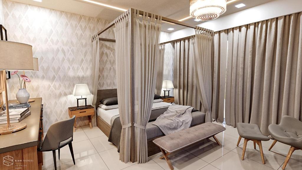 1 dormitorio con 1 cama, escritorio y sillas en Hotel Matheo Villas & Suites, en Malia