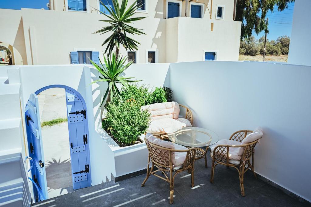 un patio con mesa y sillas y un edificio en Studio Kocis en Monolithos
