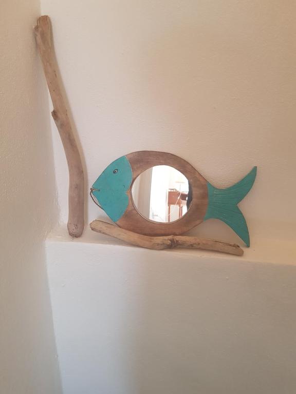 a wooden fish mirror on a shelf in a room at Charmant 2 pièces en plein coeur du village in Cargèse