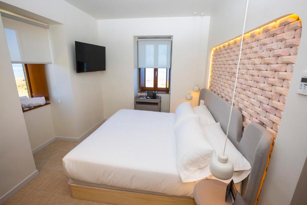 Postel nebo postele na pokoji v ubytování Hotel Faro Lariño