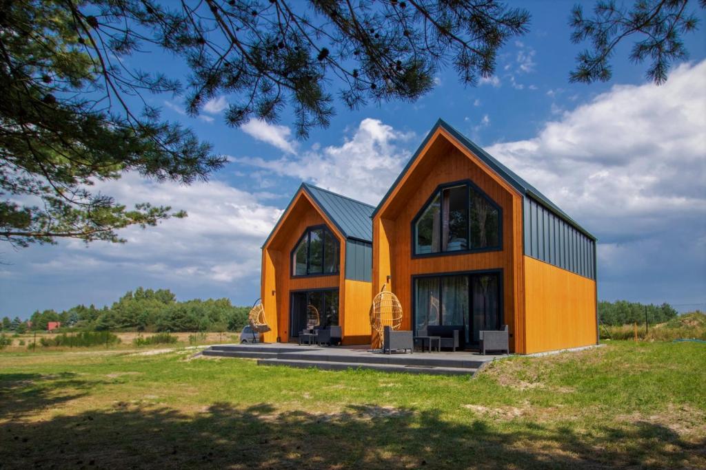 a house with an orange and black facade at Nella Foresta in Ostrowo