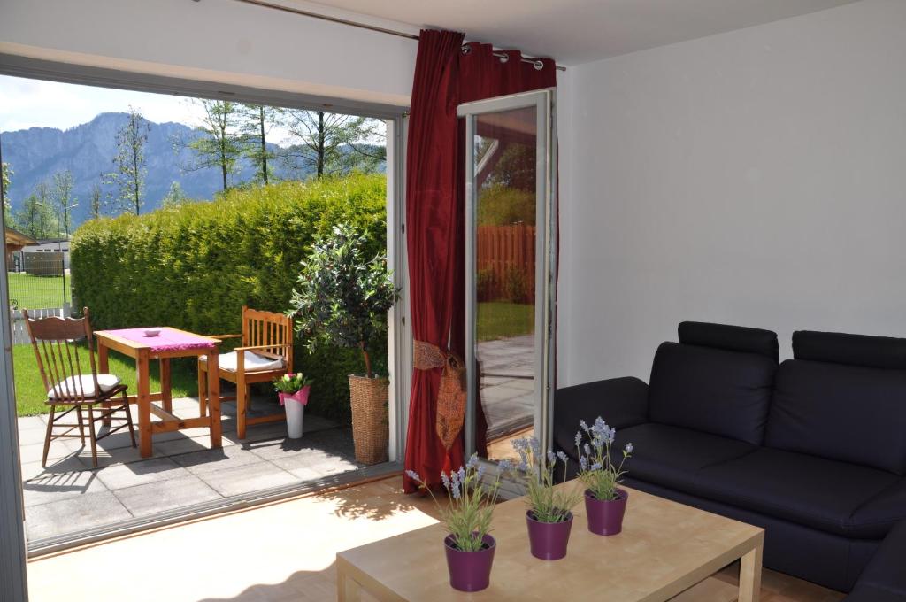 ein Wohnzimmer mit einem Sofa und einem Tisch in der Unterkunft Ferienwohnung Alpenseepark in Mondsee