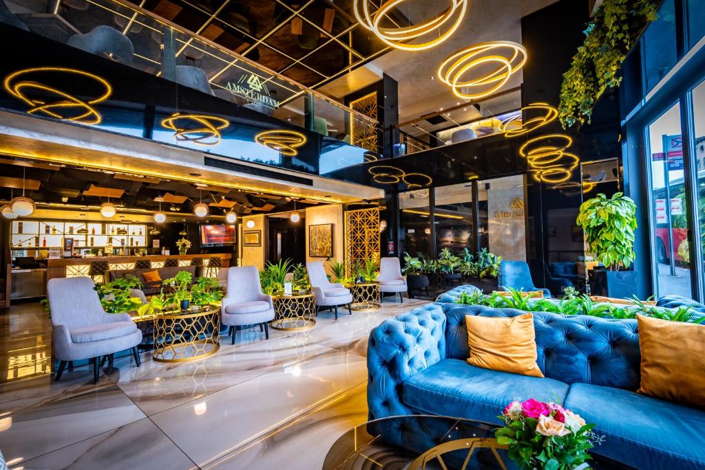 a lobby of a restaurant with blue couches and chairs at Amsterdam Hotel in Belgrade