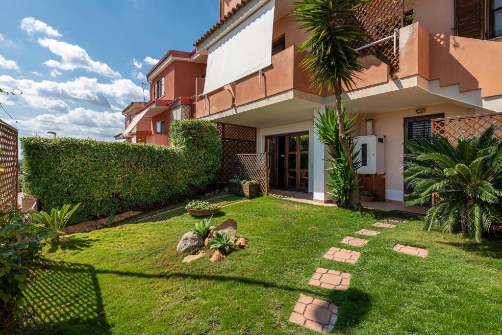 a backyard of a house with a grass yard at Casa Michelle in Villaputzu