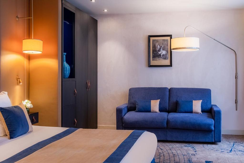 a bedroom with a bed and a blue couch at Hôtel La Bourdonnais by Inwood Hotels in Paris