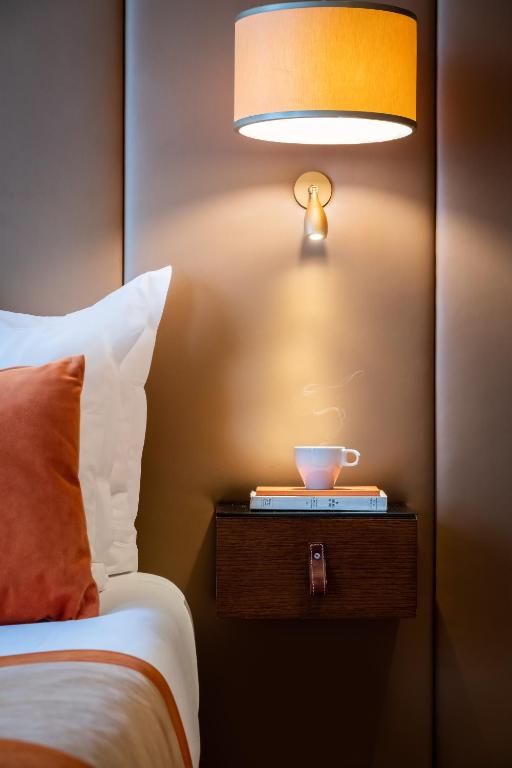 a lamp on a night stand next to a bed at Hôtel La Bourdonnais by Inwood Hotels in Paris