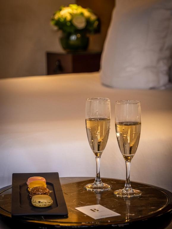 two glasses of champagne and a plate of food on a table at Hôtel La Bourdonnais by Inwood Hotels in Paris
