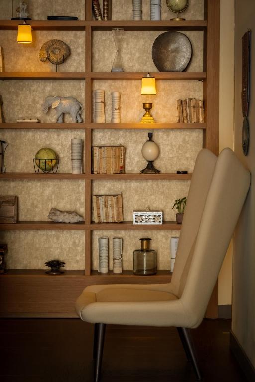 a white chair sitting in front of a book shelf at Hôtel La Bourdonnais by Inwood Hotels in Paris
