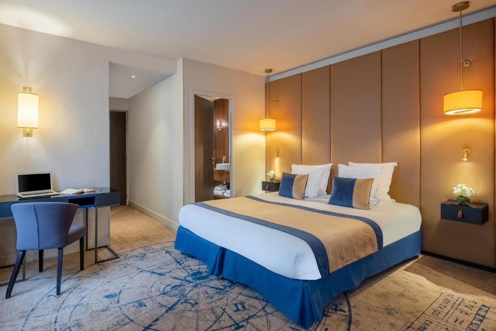 a hotel room with a large bed and a desk at Hôtel La Bourdonnais by Inwood Hotels in Paris