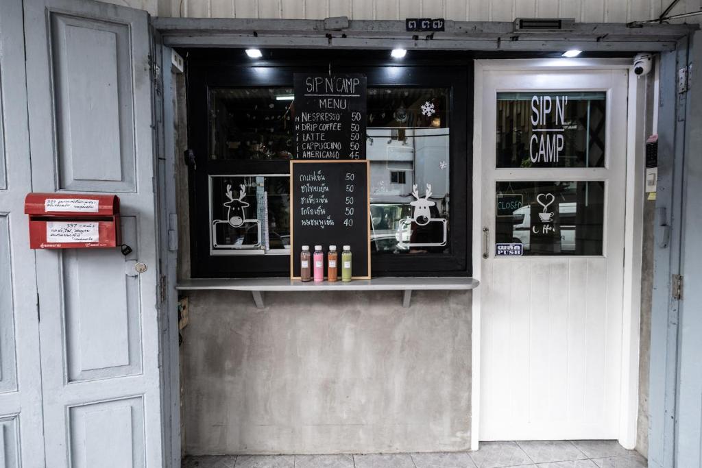 een winkel voor een winkel met een bord op de deur bij Sip N' Camp in Bangkok