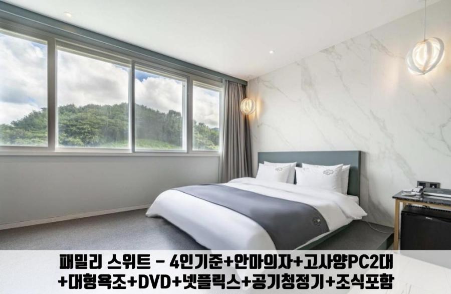 a bedroom with a bed and a large window at Gimhae Jangyu Stayin Hotel in Gimhae