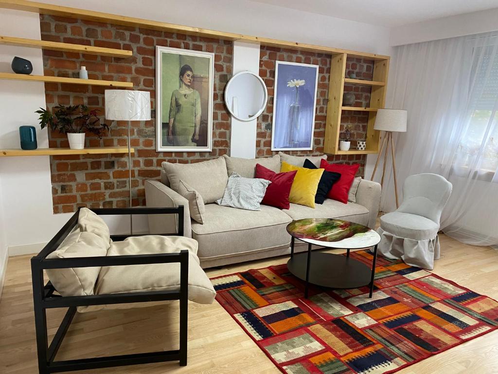 a living room with a couch and a brick wall at Bastion Apartament 4 in Timişoara