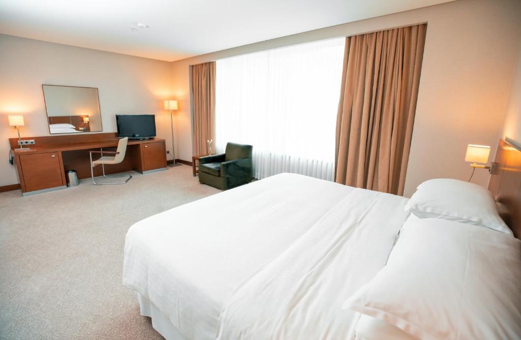 a hotel room with a white bed and a desk at FLY INN BAKU in Baku