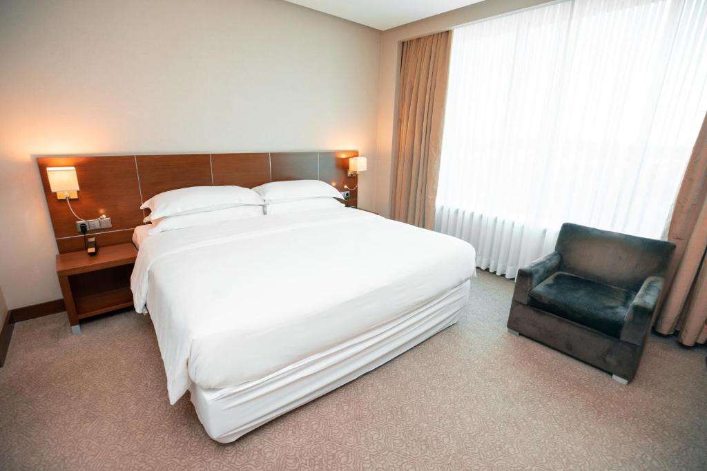 a hotel room with a large bed and a chair at FLY INN BAKU in Baku
