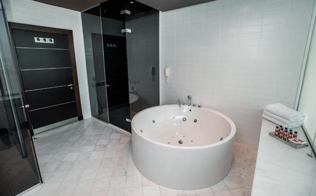 a large white tub in a bathroom with a shower at FLY INN BAKU in Baku