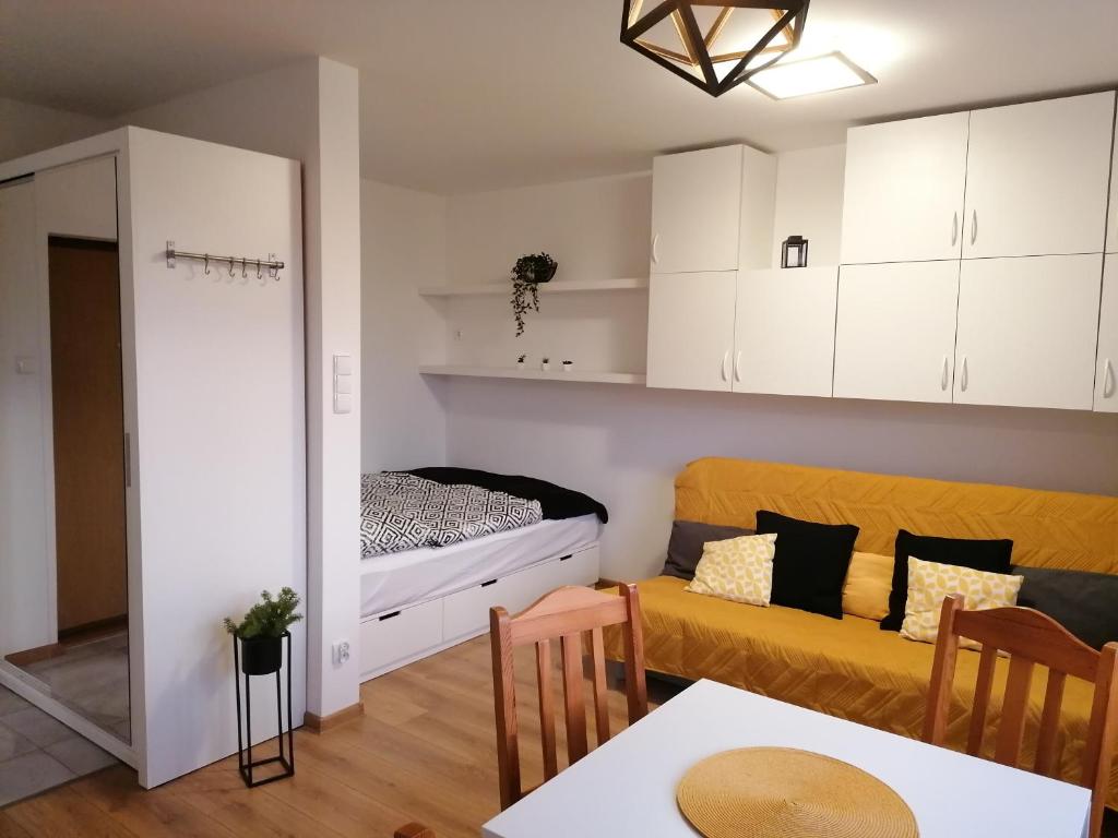 ein Wohnzimmer mit einem Sofa und einem Bett in der Unterkunft Mieszkanie z widokiem koło Ergo Areny in Danzig