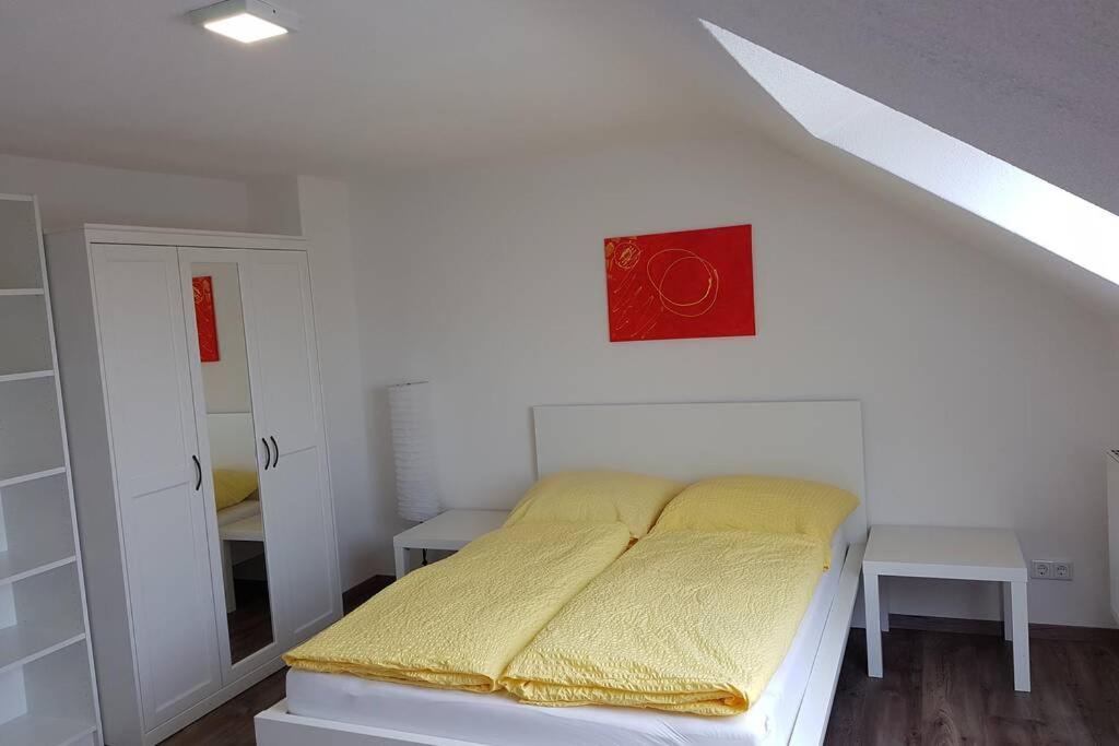 a bedroom with a bed with a red clock on the wall at Dachwohnung Eyb mit 3 Schlafzimmern in Ansbach