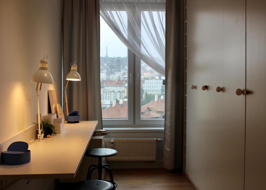 um quarto com uma secretária e uma grande janela em TopView City Centre em Bratislava