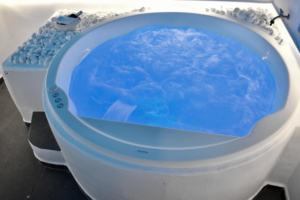 a toilet with a blue water inside of it at Ariana Eco Suites Adults Only in Fira