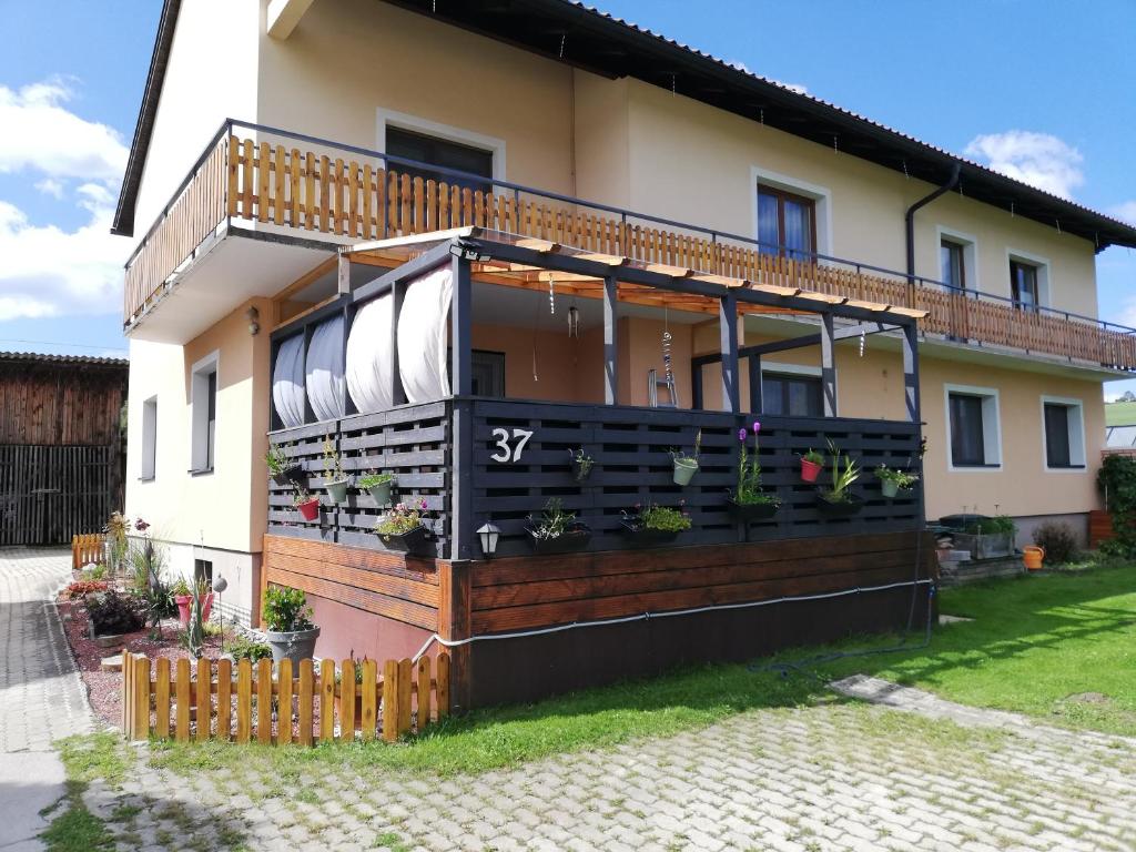 una casa con un balcón con plantas. en Haus Petra, en Neumarkt in Steiermark