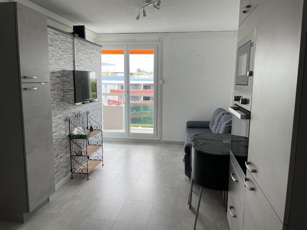 Habitación con cocina con mesa y TV. en Bormes-les-Mimosas - Appart 25m2 avec balcon - 4P, en Bormes-les-Mimosas