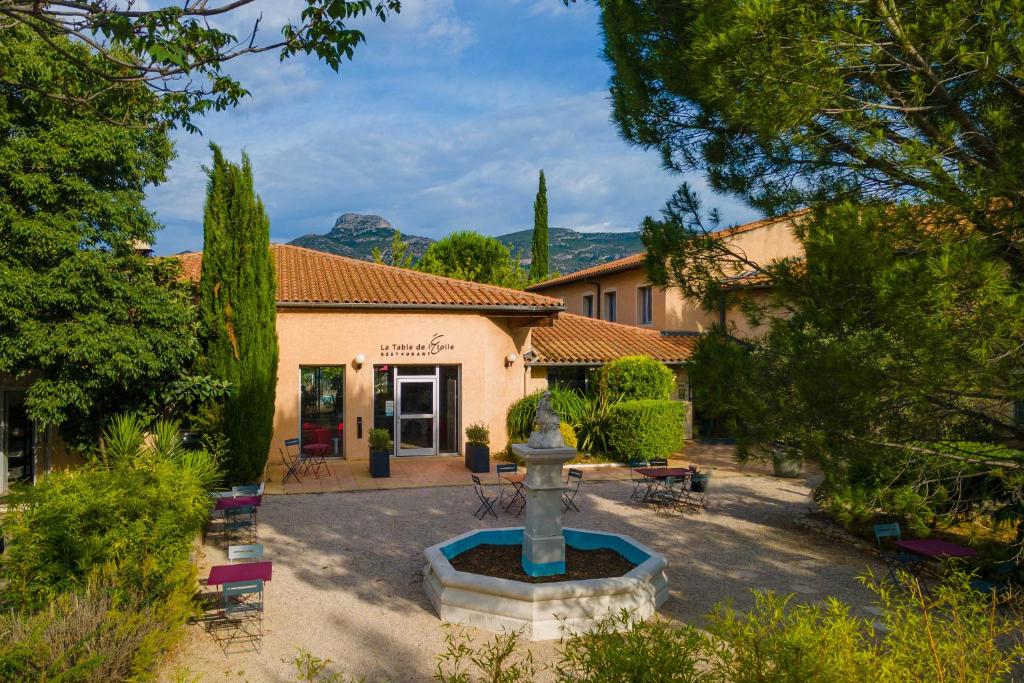 a courtyard with a fountain in front of a building at Logis Noemys pont de l'Etoile - ex Mas de L'Etoile in Aubagne