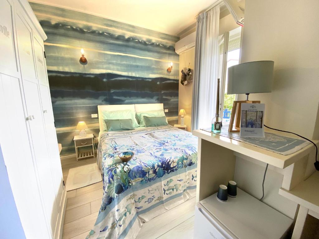 チンクアレにあるB&B Due Passi dal Mareのベッドルーム1室(ベッド1台付)が備わります。壁には絵画が飾られています。