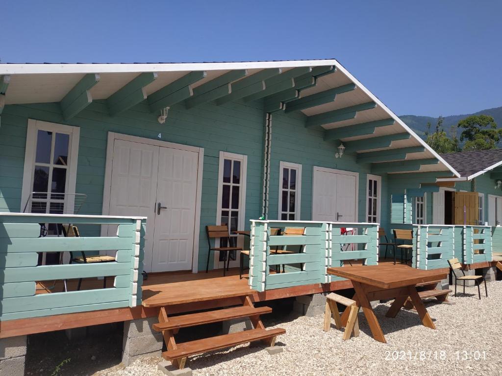 a green house with benches and tables in front of it at Lazurny in Gagra