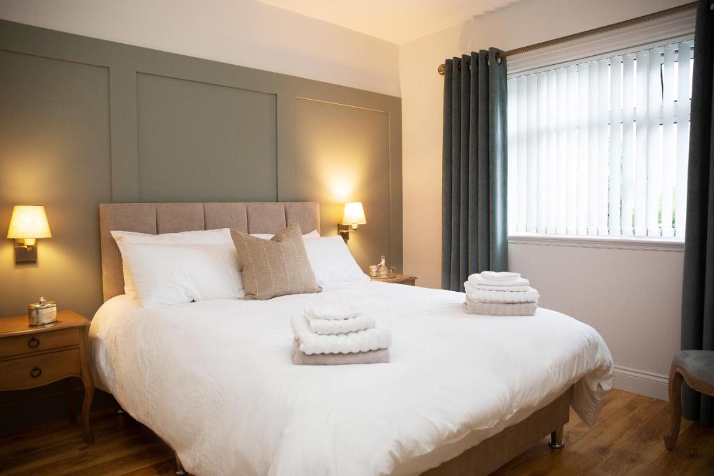 1 dormitorio con 1 cama blanca grande y toallas. en Patsy’s Corner Cottage, en Enniskillen