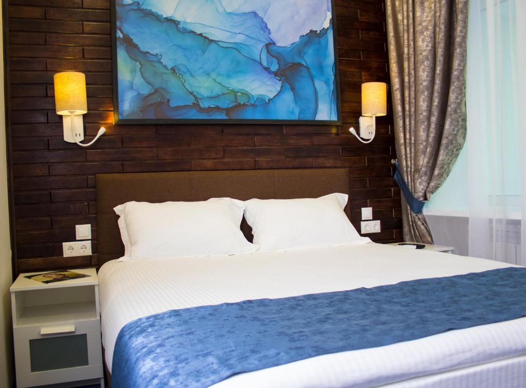 a bedroom with a bed and a painting on the wall at Hotel Lazurit in Khabarovsk