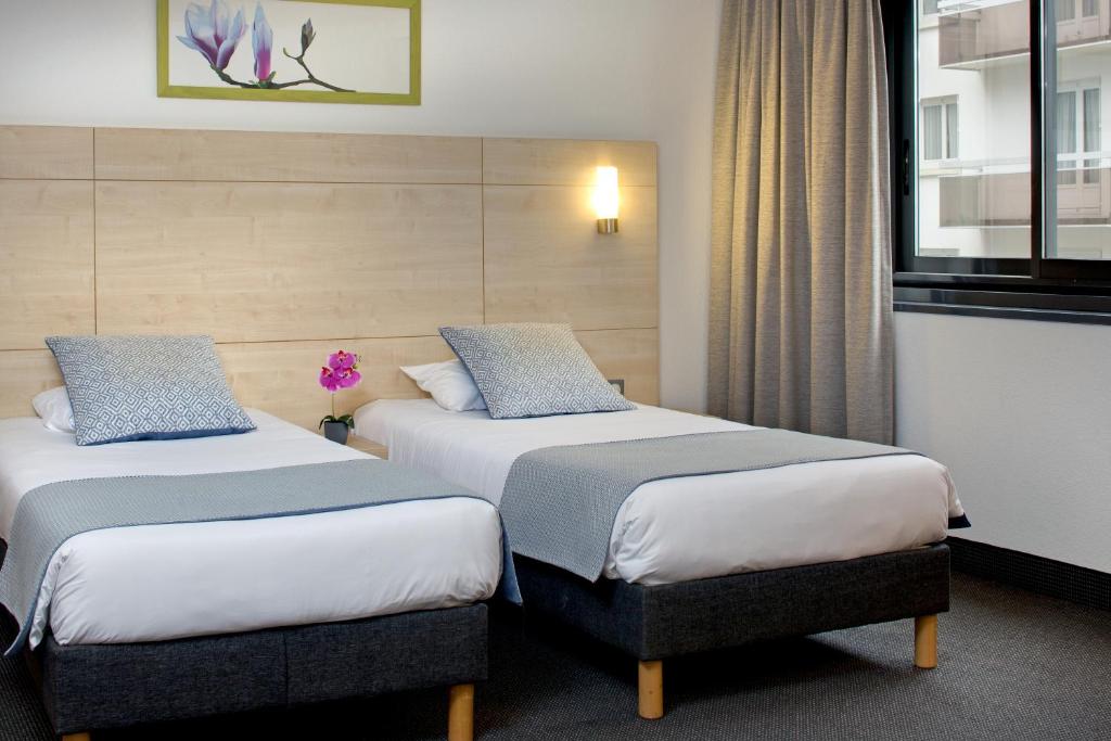 Postel nebo postele na pokoji v ubytování Hôtel Padoue