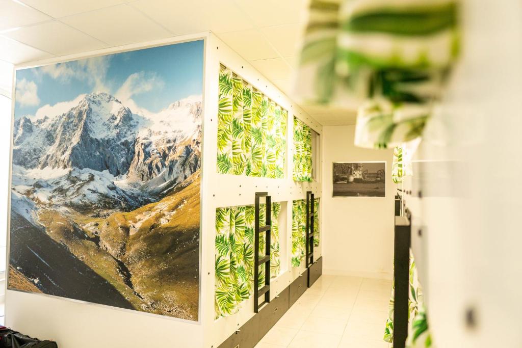 a hallway with a large picture of mountains on the wall at Hostel Playa de Merón in San Vicente de la Barquera