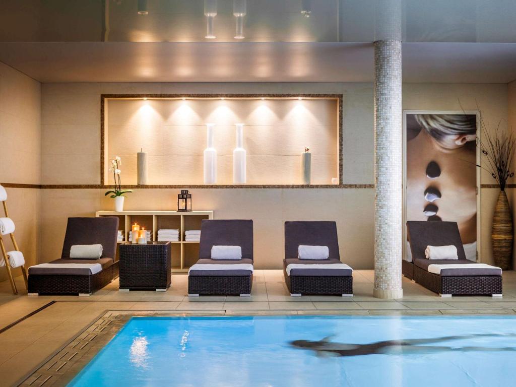 uma piscina no átrio do hotel com um golfinho em Novotel SPA Rennes Centre Gare em Rennes