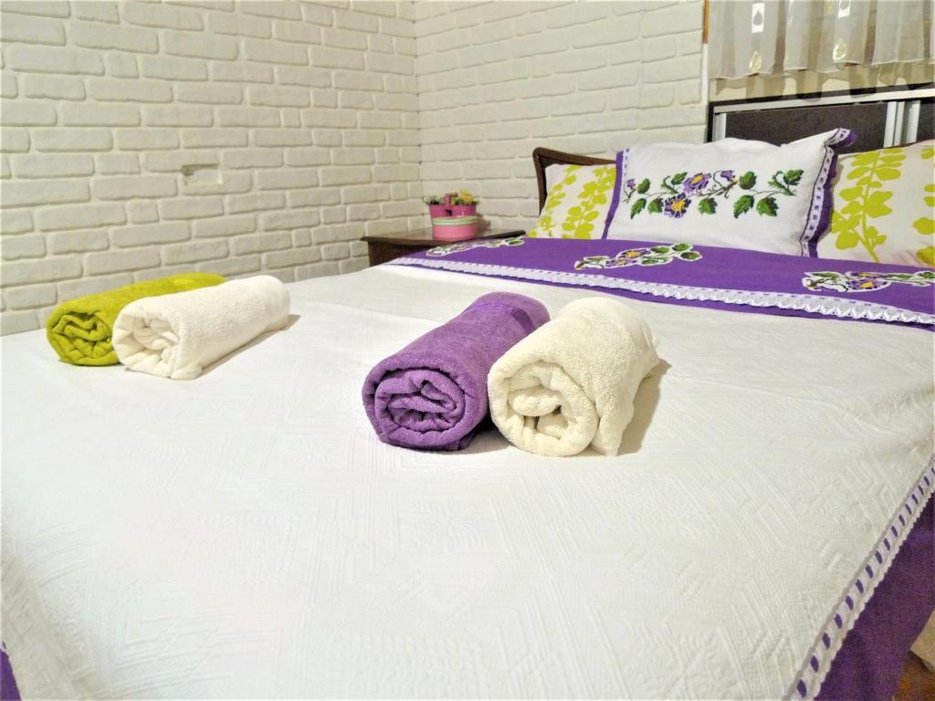 Una cama con toallas moradas y blancas. en Comfy roof with terrace - 4 TH FLOOR WITHOUT LIFT-1 Air Conditioner en Denizli