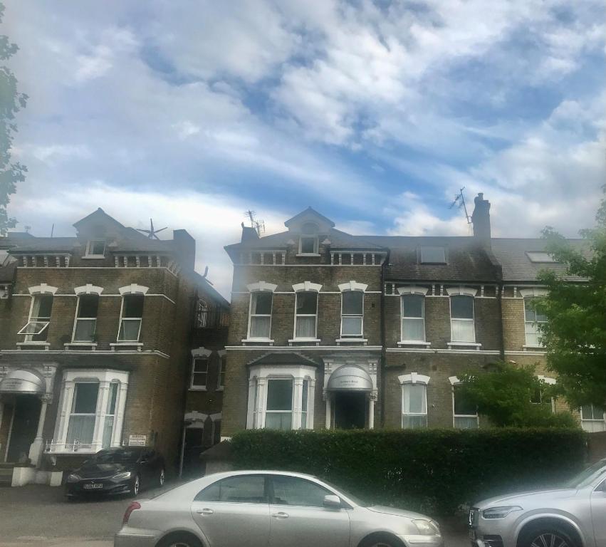 un gran edificio con coches estacionados frente a él en Amhurst Hotel en Londres