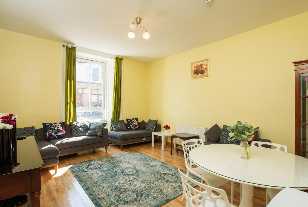 a living room with a table and a couch at 7 Bedroom Townhouse in Edinburgh