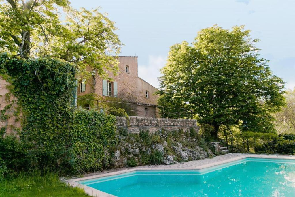 una piscina frente a una pared de piedra en Villa Terrubi en Provence au Domaine Fontainebleau, en Le Val