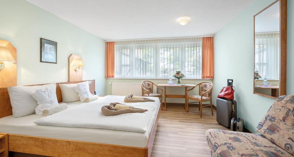 オーバーホーフにあるHotel Thüringenschanzeのベッドとテーブルが備わるホテルルームです。