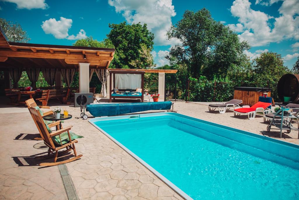 a swimming pool in a yard with a patio at Casa Ryana Gilau in Gilău